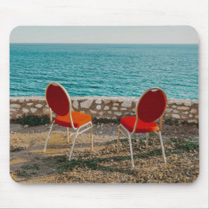 Chairs on coast of ocean under sky mouse mat