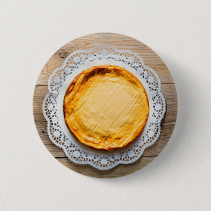 Cheesecake on rustic wood cake top. 6 cm round badge