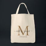 Chic Gold Monogram Script Names Wedding Date Tote Bag<br><div class="desc">Chic, modern gold monogrammed tote bag with your names and year established in black elegant hand lettered script calligraphy with a gold monogram. Simply add your names, monogram and year established beneath. Stylish design and perfect gift for the wedding guests of the newlywed couple. If you need any help or...</div>