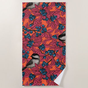 Chickadee birds on blueberry branches on orange beach towel