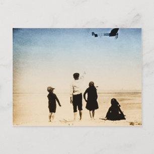 Children watching aeroplane on the beach postcard