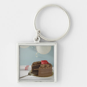 Chocolate cake with missing slice on table, key ring