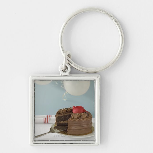 Chocolate cake with missing slice on table, key ring (Front)