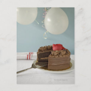 Chocolate cake with missing slice on table, postcard