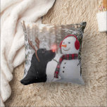 Christmas Black Labrador Retriever with Snowman Cushion<br><div class="desc">A black Labrador retriever with a glowing red nose and reindeer antlers stands beside a snowman in a winter forest</div>
