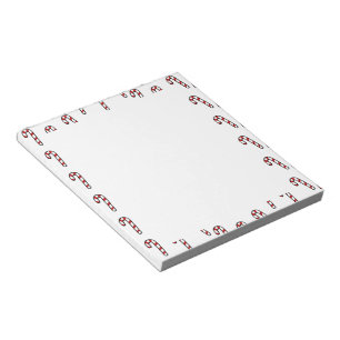 Christmas candy cane on white notepad