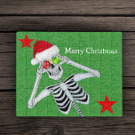 Christmas Laughing Skeleton Ornament Eyes Stars  Jigsaw Puzzle<br><div class="desc">This acrylic jig saw puzzle has a laughing skeleton wearing a Santa hat holding red and green snowflake ornaments up to his eyes on a green background with gold specks and two red stars.  Customise the Merry Christmas text with the template.</div>