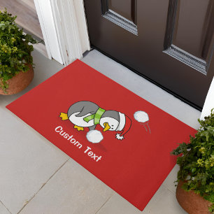 Christmas penguin getting a snow ball doormat