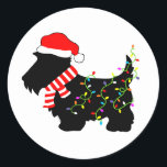 Christmas Scottie Dog With Lights Classic Round Sticker<br><div class="desc">Scottish Terrier dog lovers will enjoy this festive,  black Scottie Dog wearing a Santa hat,  red and white striped scarf and colourful string lights!  Get into the Christmas spirit with this funny design on customisable gifts!</div>