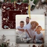 Christmas Script Photo Boho Greenery Christmas Ceramic Ornament<br><div class="desc">This simple photo Christmas ornament features "Merry Christmas" in an elegant modern script and custom text for you family name. The backside offers a boho winter greenery pattern appearing in soft tans and teals on a deep dark burgundy background and offers extra text for first names of your family members....</div>