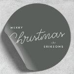 Christmas Stickers | Forest Green Holiday Labels<br><div class="desc">A trendy and stylish holiday round sticker featuring modern and handwritten script typography in white on a deep smoky green-gray background. Perfect for adding a refined touch to Christmas gifts, envelopes, or product packaging, this minimalist design blends simplicity with modern festive charm. Easily personalize the name in Zazzle’s design tool...</div>