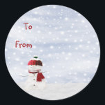 Christmas Sticky Label Gift Tag<br><div class="desc">A handy Christmas sticky label gift tag featuring a snowman wearing a red and green bobble hat and scarf against an attractive blue and snowy sky.  The words 'To' and 'From' on the label can be customised according to your own preference.</div>