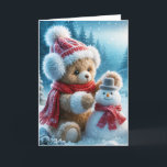 Christmas Teddy Bear Building a Snowman Holiday Card<br><div class="desc">A brown teddy bear in a hat,  earmuffs,  and red scarf builds a small snowman in a winter woods</div>
