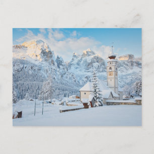 Church covered in snow with mountain background postcard
