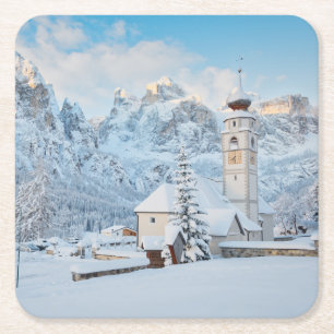 Church covered in snow with mountain background square paper coaster