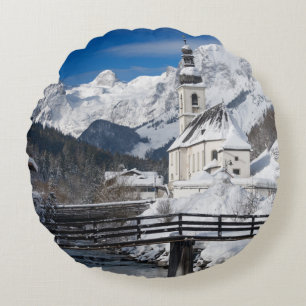Church in the snow with Alps mountains Round Cushion