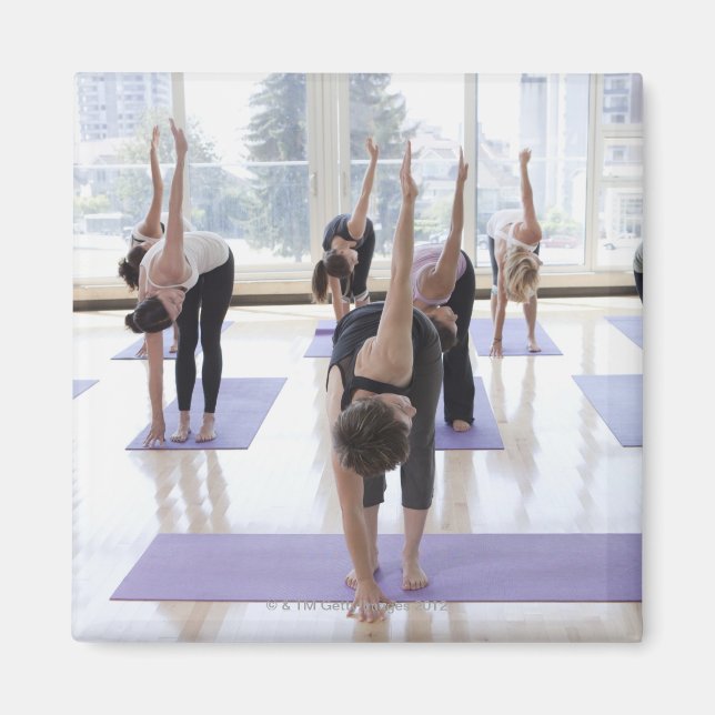 class practicing yoga with instructor in a magnet (Front)