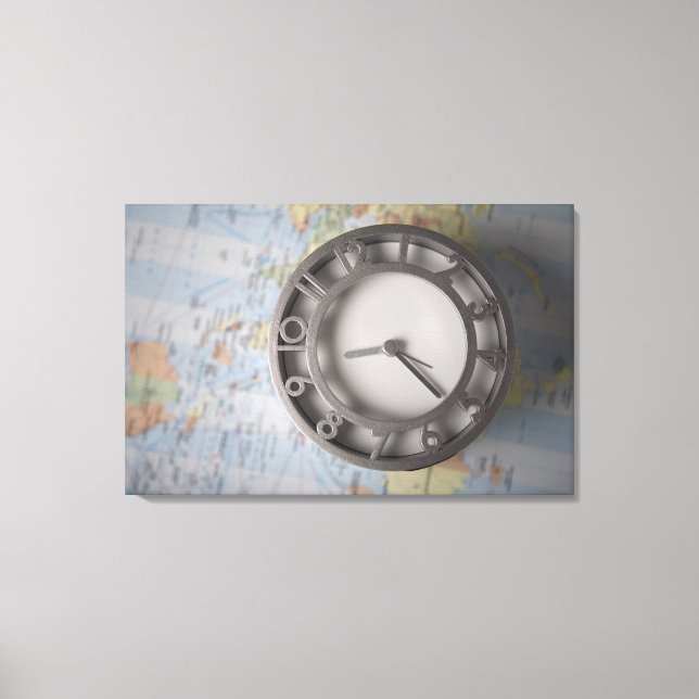 Close-up of a clock in front of a map canvas print (Front)