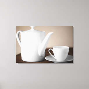 Close-up of a cup and a saucer with a tea kettle canvas print