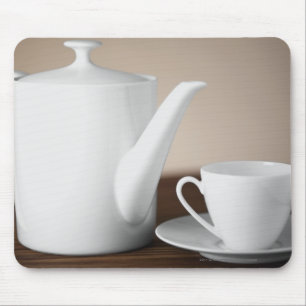 Close-up of a cup and a saucer with a tea kettle mouse mat