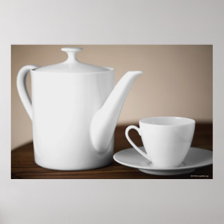 Close-up of a cup and a saucer with a tea kettle poster