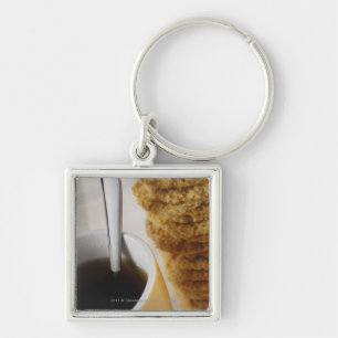 Close-up of a cup of coffee with cookies key ring