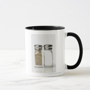 Close-up of a salt and a pepper shaker mug