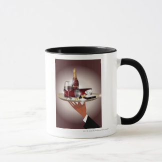 Close-up of a waiter's hand holding a tray mug