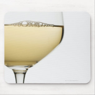 Close up of glass of white wine on white mouse mat