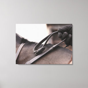 close-up of hand holding reins of horse canvas print