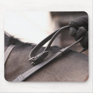 close-up of hand holding reins of horse mouse mat