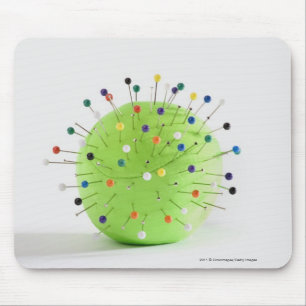 Close-up of straight pins inserted into a ball mouse mat