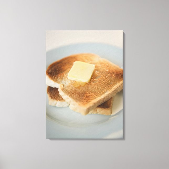 Close up of toasts with butter on plate canvas print (Front)
