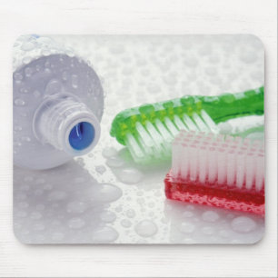 Close-up of toothpaste and toothbrushes covered mouse mat