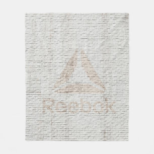 Close-up photo of Reebok logo on wall Fleece Blanket