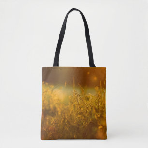 Close up silhouette of a grass field by sunsetabst tote bag