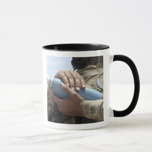 Close-up view of a soldier cradling a munition mug