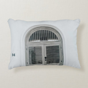 CLOSED GREY WOODEN DOOR BELOW BLACK LIGHT SCONCE DECORATIVE CUSHION