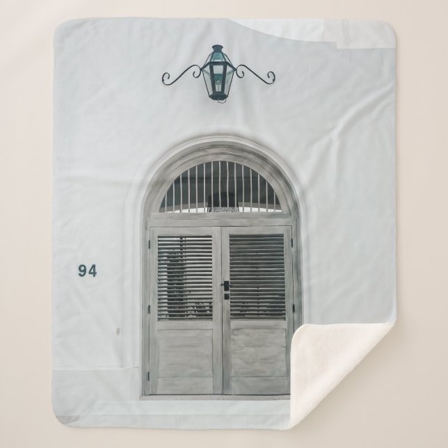 CLOSED GREY WOODEN DOOR BELOW BLACK LIGHT SCONCE SHERPA BLANKET (Front)