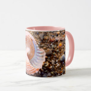 COASTAL DESIGN WITH PINK SEA SHELL ON STONY BEACH MUG