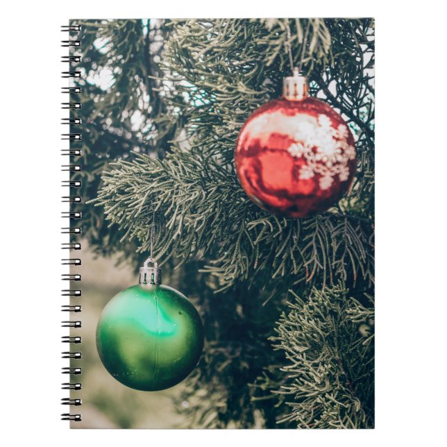 Colourful Christmas bauble decoration on a tree. V Notebook (Front)