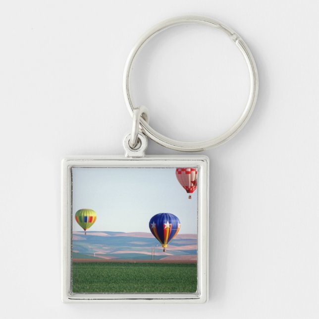 Colourful hot air balloons float over wheat key ring (Front)