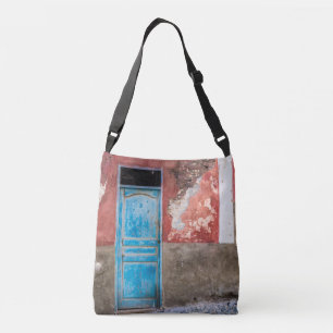 Colourful wall with blue door crossbody bag