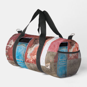 Colourful wall with blue door duffle bag