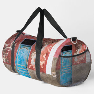 Colourful wall with blue door duffle bag