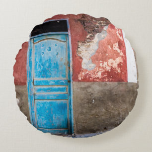 Colourful wall with blue door round cushion