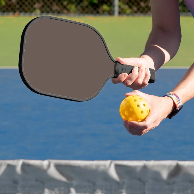 Confidently Against a Stylish Brown Wall Pickleball Paddle (Insitu)