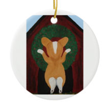 Corgi putting Christmas Wreath on Doghouse