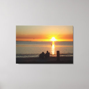 Couple Sit On Beach At Sunset Canvas Print