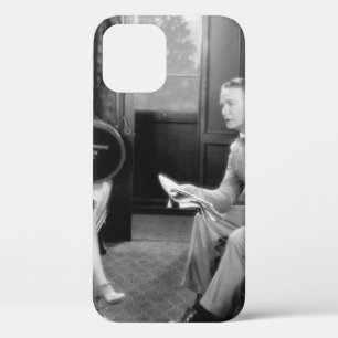 Couple sitting together in a compartment of a trai iPhone 12 case